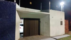 uma porta para um edifício com estacionamento à noite em CASA DE TEMPORADA RECANTO FELIz 2 em Aracaju