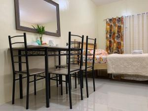 a room with a table and chairs and a bed at A comfy retreat in the heart of Orani, Bataan in Orani