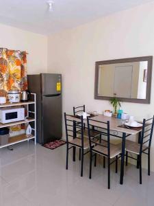 a dining room with a table and a refrigerator at A comfy retreat in the heart of Orani, Bataan in Orani