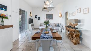 a dining room and living room with a table and chairs at VILLA SOLELUNA 7&1, Emma Villas in Marittima