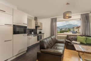 a kitchen and living room with a couch and a table at Ferienhaus Kesselgrub in Altenmarkt-Zauchensee in Altenmarkt im Pongau