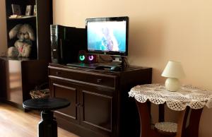 a room with a tv and a table with a stool at STONE GARDEN 2 in Liepāja