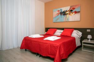 una camera da letto con un letto rosso e asciugamani bianchi di Camelot Red - Appartamenti a Verona