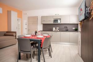una cucina e una sala da pranzo con tavolo e sedie di Camelot Red - Appartamenti a Verona