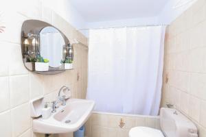 a bathroom with a sink and a mirror and a toilet at Angela's flat studio - Dassia Corfu in Kato Korakiana
