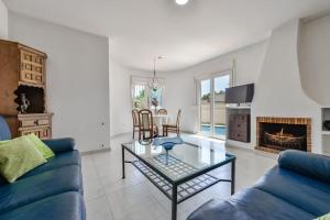 Villas Guzman - Sebastian في مورايرا: غرفة معيشة مع أريكة زرقاء وطاولة