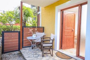 a patio with a table and chairs and a door at Angela's flat studio - Dassia Corfu in Kato Korakiana