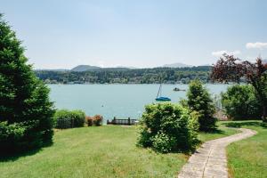 widok na jezioro z łodzią w wodzie w obiekcie Villa Fernblick w mieście Velden am Wörthersee