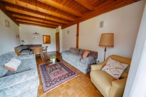 a living room with two couches and a table at Villa Fernblick in Velden am Wörthersee