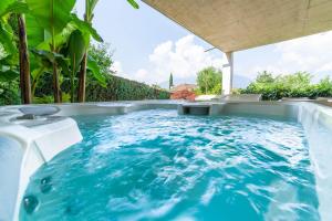 a hot tub in a backyard with blue water at Villa Alvarium in Schenna