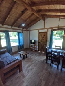 uma sala de estar com uma cama e uma mesa em Riberas del Azul em Lago Puelo