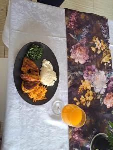 a table with a plate of food and a glass of orange juice at Jate Guest House in Maseru
