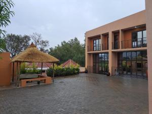 a building with a bench and a straw umbrella at Jate Guest House in Maseru