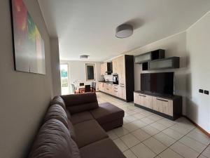 sala de estar con sofá y TV de pantalla plana en Appartamento Mimosa - Immobili e Soluzioni Rent, en Brembate