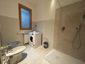 y baño con ducha y lavadora. en Appartamento Mimosa - Immobili e Soluzioni Rent, en Brembate