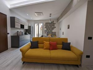 un sofá amarillo en una sala de estar con cocina en Santeria Modern Loft en Tortolì
