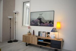 uma sala de estar com uma mesa e um espelho em Santeria Modern Loft em Tortolì
