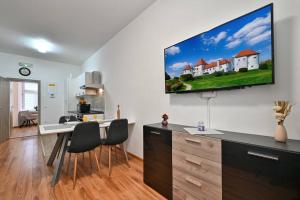 a kitchen and living room with a tv on the wall at Exclusive Palace App 3 Varaždin in Varaždin