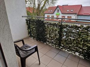 Apartament u Margherity في أنسكو: كرسي جالس على بلكونه بجانب سياج
