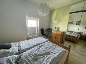 a bedroom with a bed and a dresser and a mirror at Schöne einfache zentrale Ferienwohnung über den Dächern der Stadt in Bremerhaven