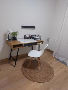 a desk with a white chair in a room at Apartamento Brisa de Santander in Santander