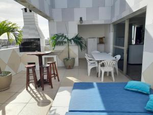 Cette chambre dispose d'un balcon avec une table et des chaises. dans l'établissement luxuosa cobertura praia do futuro 1002, à Fortaleza