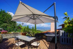 un tavolo e sedie con ombrellone su un patio di I Brichi, un paradiso immerso nella natura. a Lerici