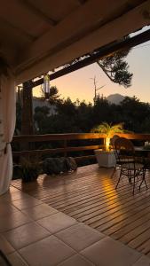 eine Holzterrasse mit einem Tisch und Stühlen darauf in der Unterkunft Pousada Casa Florinda in Teresópolis