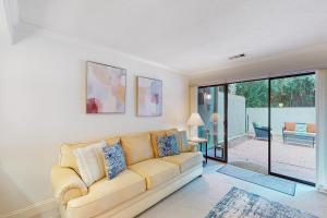 een woonkamer met een bank en een glazen schuifdeur bij Hilton Head Beach Club Villas 2 in Hilton Head Island