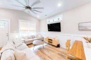 sala de estar con muebles blancos y TV de pantalla plana en Pawsitive Island Escape, en Oak Island