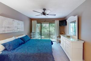 een slaapkamer met een bed en een dressoir met een spiegel bij Hilton Head Beach Club Villas 2 in Hilton Head Island