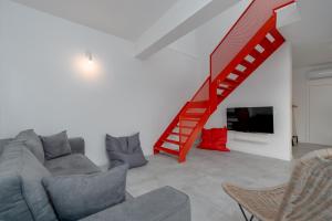 a living room with a couch and a red staircase at Villa Dream Island in Paljuv