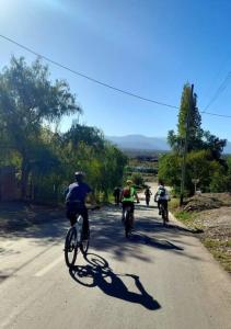 a group of people riding bikes down a road at La cabaña de Tito. in Ciudad Lujan de Cuyo