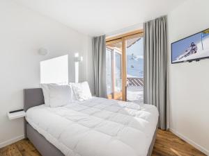 un grande letto bianco in una stanza con finestra di Appartement Val Thorens, 3 pièces, 6 personnes - FR-1-640-23 a Val Thorens