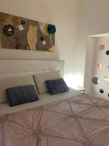 um quarto com uma cama com duas almofadas e um quadro em BORGO DEGLI STUDI 7 em Parma