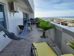einen Balkon mit Hängematten und Stühlen auf einem Gebäude in der Unterkunft luxuosa cobertura praia do futuro 1002 in Fortaleza