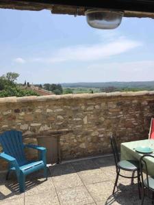 un patio avec des chaises et une table et un mur en pierre dans l'établissement Uzès proche,charmant pied a terre avec terrasse, à La Bastide-dʼEngras 10 autres photos