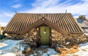 un piccolo edificio in pietra con una porta verde di Nice Home In Gol With Kitchen a Golsfjellet