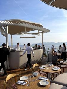 un gruppo di persone in piedi in un bar su uno yacht di Beach Studio Cannes a Cannes