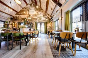 a restaurant with tables and chairs in a room at Glamping Valkenburg in Meerssen