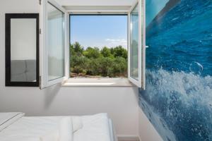 a bedroom with a window and a painting on the wall at Sunrise Apartment Hvar in Hvar