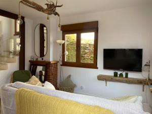 uma sala de estar com um sofá e uma televisão de ecrã plano em 14A06 Casa Pepe em La Isla
