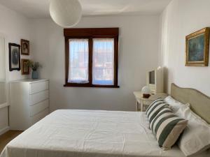 a white bedroom with a large bed and a window at 14A06 Casa Pepe in La Isla