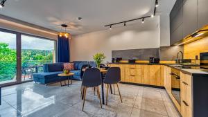 una cucina e un soggiorno con divano e tavolo di Apartamenty z basenem i saunami ROYAL APARTS VIP Stone Hill Centrum a Szklarska Poręba