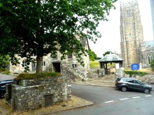 a car parked in front of a church with a tower at The Old Seven Stars in Okehampton