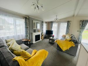uma sala de estar com um sofá e uma televisão em Lakeside View Lodge with Hot Tub em York