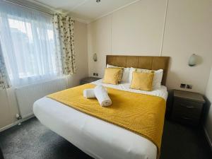 a bedroom with a large bed with two towels on it at Lakeside View Lodge with Hot Tub in York