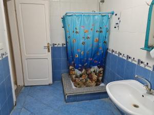 La salle de bains est pourvue d'une douche avec un rideau de douche pour les poissons. dans l'établissement Villa 24 Apollo, à Dawwār Ibrāhīm Abū Shunaywīr