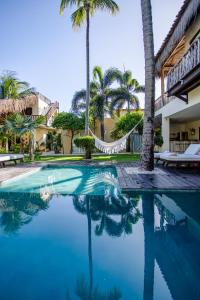 a swimming pool in a resort with palm trees at Casa Elea in Jericoacoara