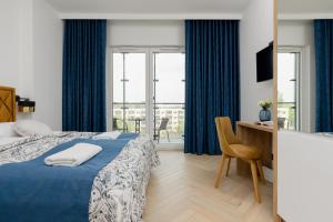 ワルシャワにあるBusiness Apartments Kasprzaka by Noclegi Rentersのベッドルーム1室(青いカーテン、デスク付) +70枚の写真